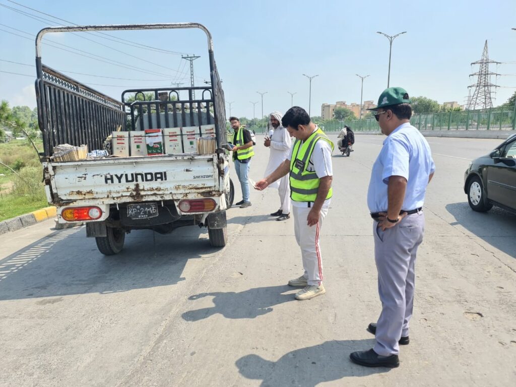 پاک ای پی اے اہلکار اسلام آباد کی سڑک پر دھواں چھوڑنے والی گاڑیوں کی چیکنگ اور جرمانہ کرتے ہوئے، فضائی آلودگی اور اسموگ پر قابو پانے کے لیے کارروائی