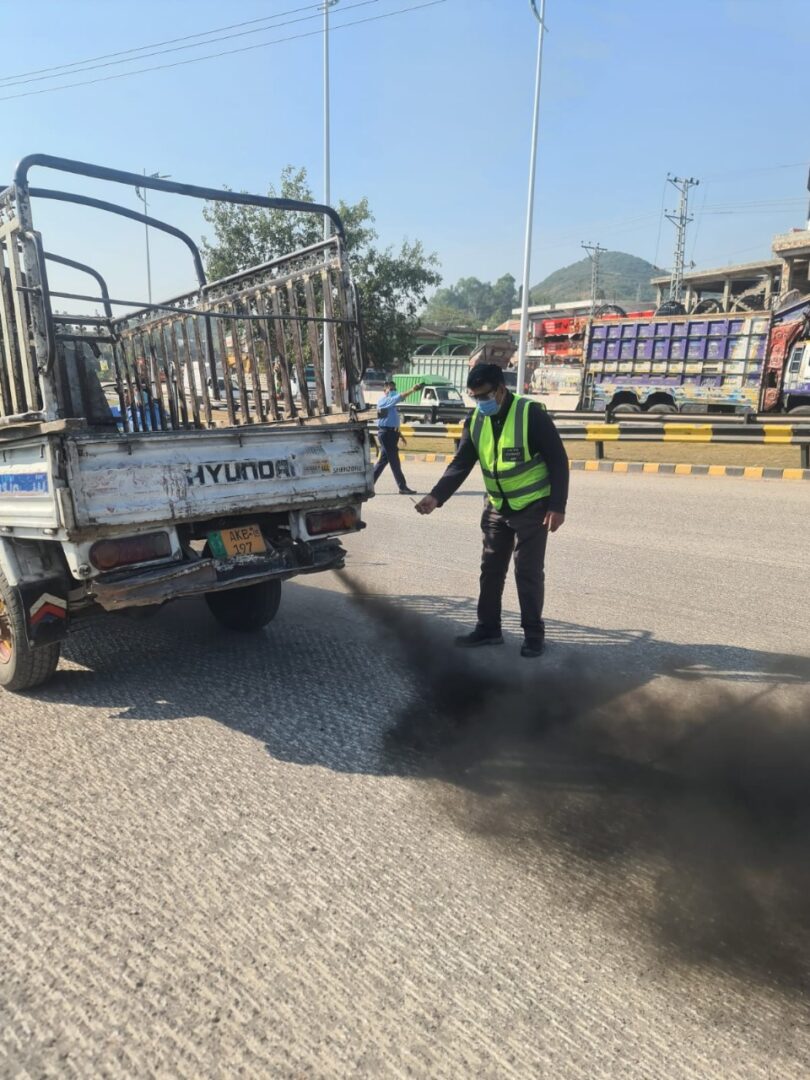 پاک ای پی اے اہلکار اسلام آباد کی سڑک پر دھواں چھوڑنے والی گاڑیوں کی چیکنگ اور جرمانہ کرتے ہوئے، فضائی آلودگی اور اسموگ پر قابو پانے کے لیے کارروائی