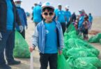 Children of Generation Alpha cleaning the beach with gloves and tongs at Karachi Sea View, promoting environmental awareness