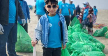 Children of Generation Alpha cleaning the beach with gloves and tongs at Karachi Sea View, promoting environmental awareness