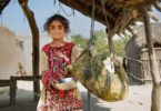 Women and children carrying water containers across rocky mountain paths in Kunraj, Balochistan due to clean water shortage