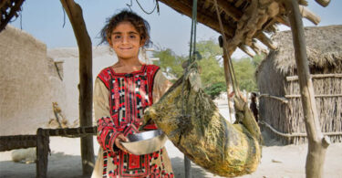 Women and children carrying water containers across rocky mountain paths in Kunraj, Balochistan due to clean water shortage