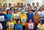 Large group of community members holding “Land Rights” signs during a gathering advocating secure land ownership.
